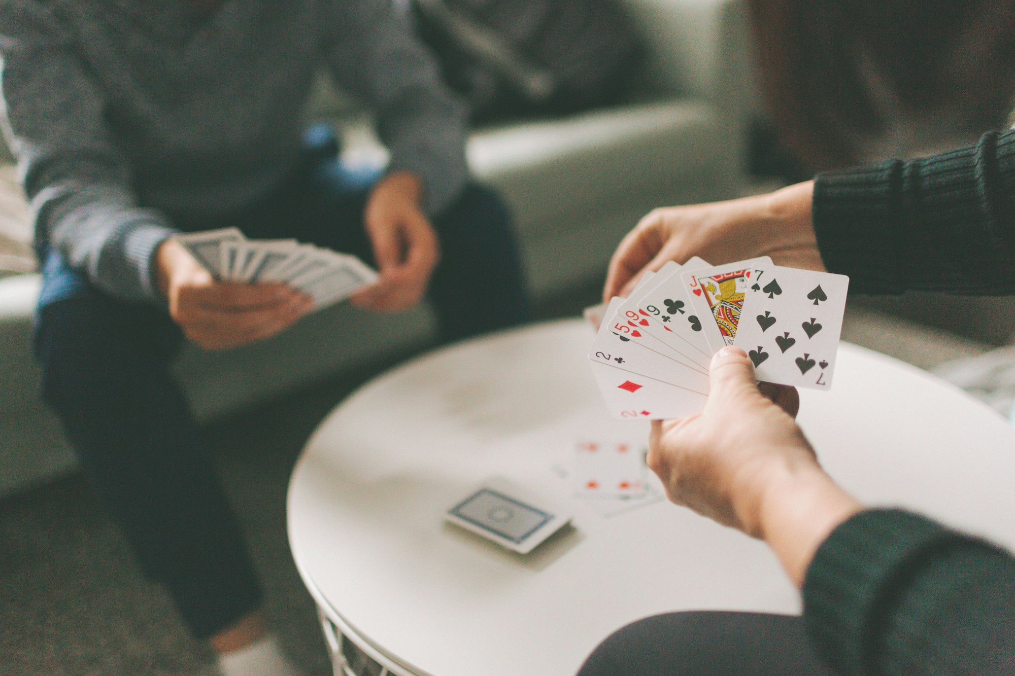 A couple playing cards indoors.